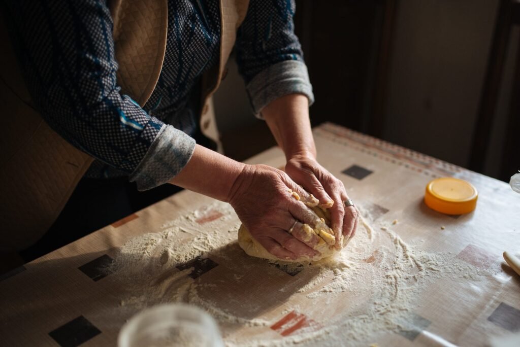 Bakery worker kneading bread dough by hand