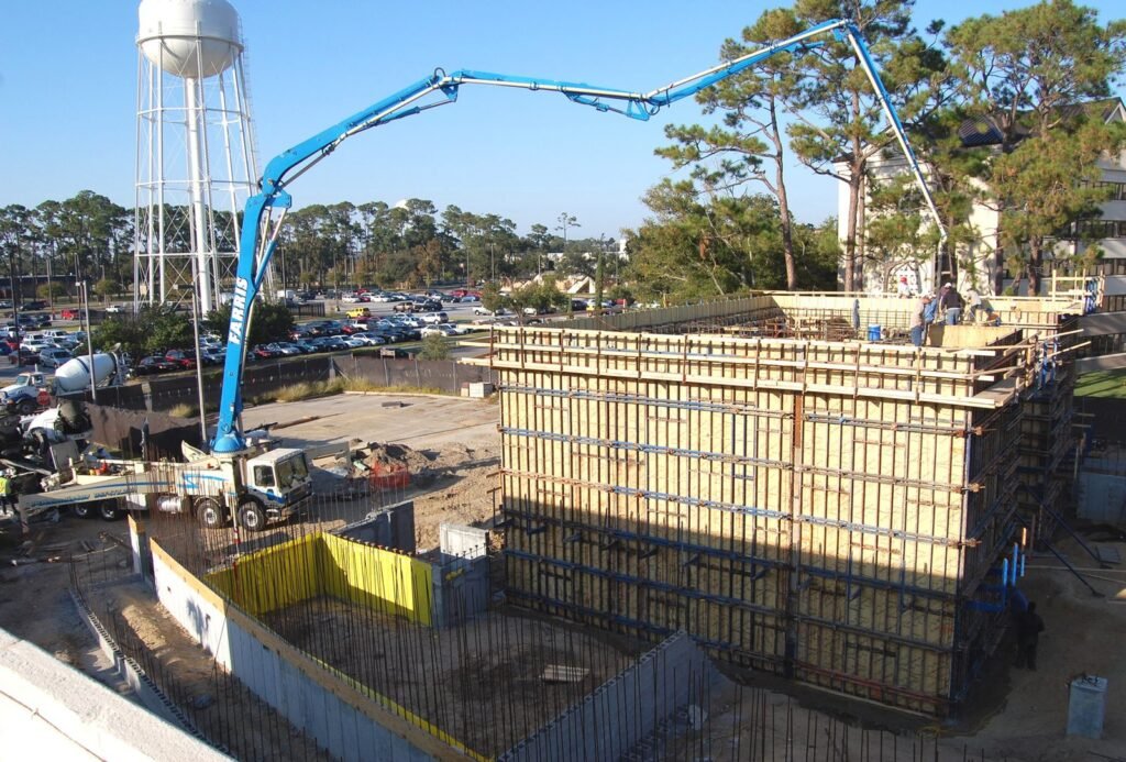 Construction site with concrete pump truck and workers